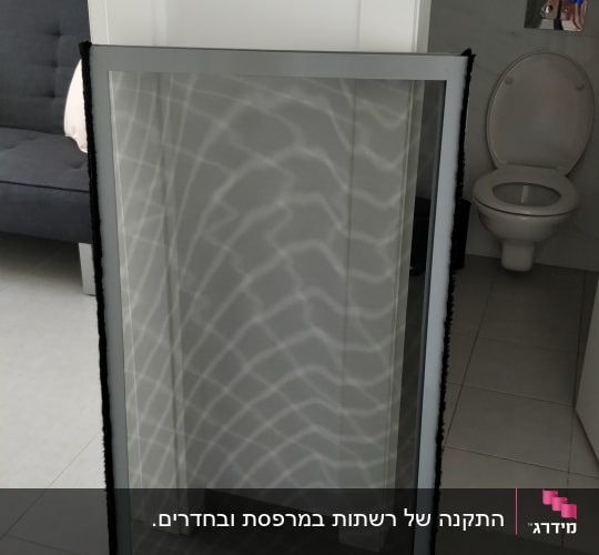 מסגרת אלומיניום עם רשת מונחת על הרצפה
